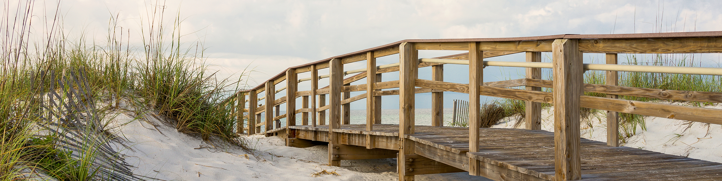 photo of a wooden walkway leading to a beach