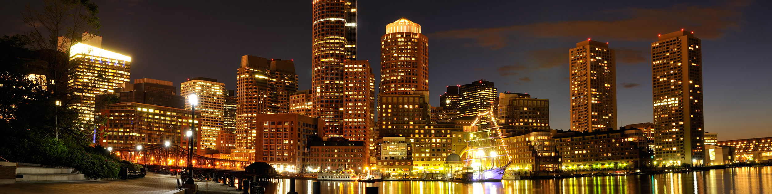 view of Boston MA skyline at night with boat in water