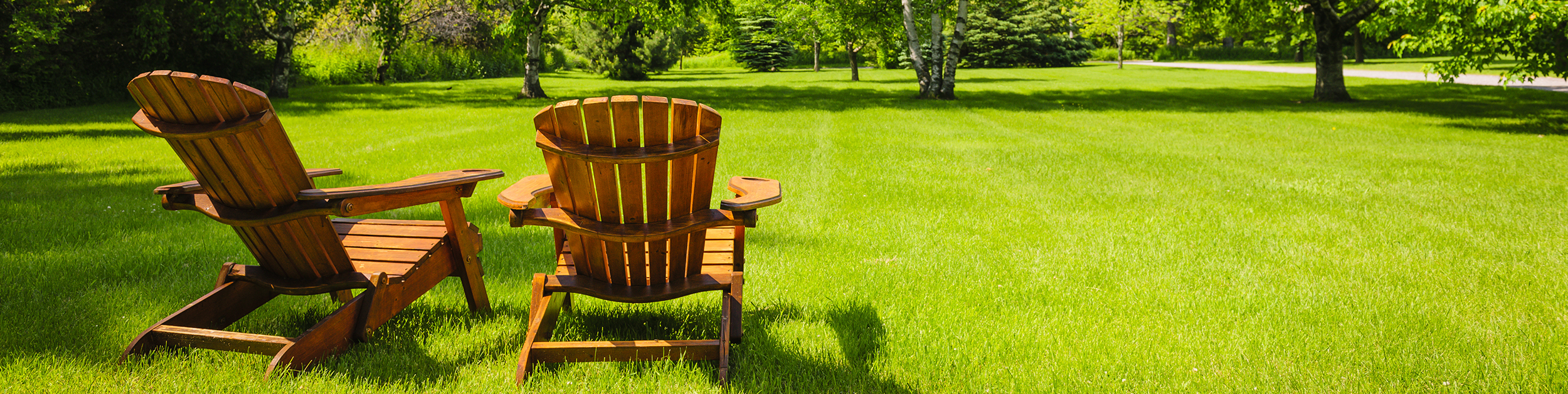 beautiful expansive lawn shown with two adirondack chairs