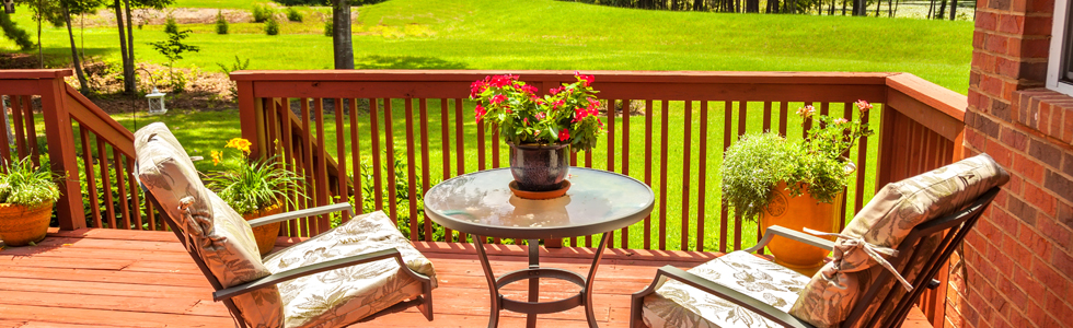 unoccupied deck furniture with flowers in the middle of the table