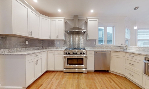 kitchen with white cabinets, stainless steel appliances and hardwood flooring