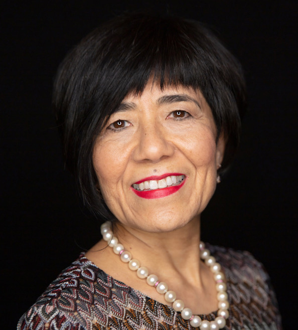 Agent photo - woman width dark hair wearing a black suit with arms crossed in front of her