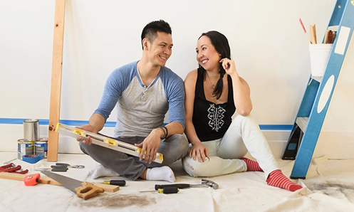 man and woman sitting on the floor surrounded by handyman tools