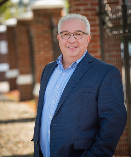 photo of Mitchell Rosenwald wearing light blue button down shirt under long sleeved dark blue sport coat