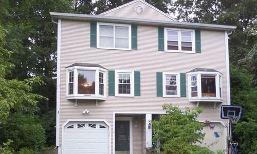 Exterior view of multi family property - tan with green shutters and white trim