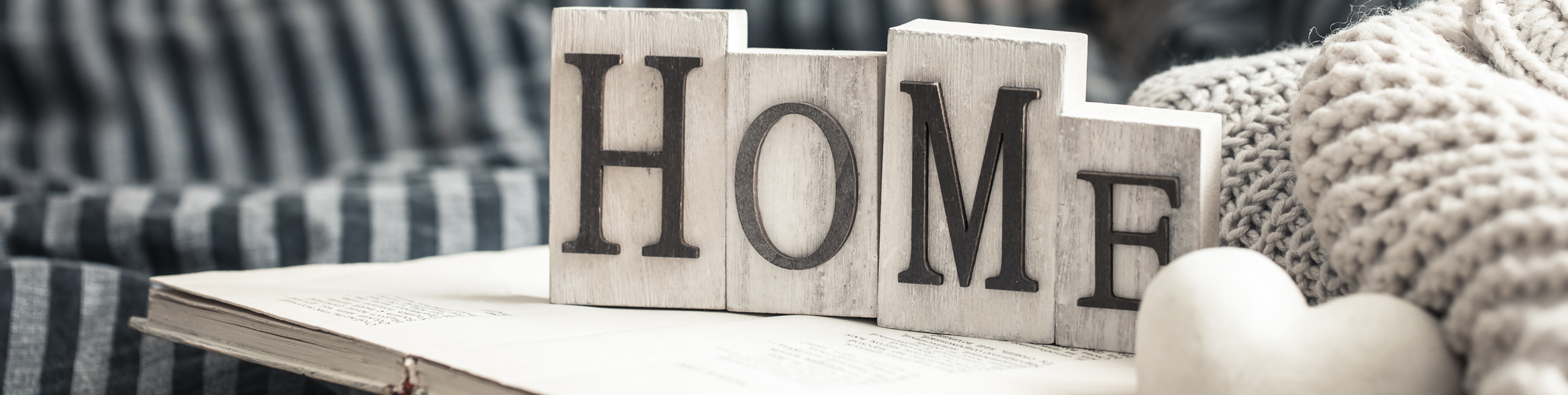 The word HOME spelled out in wooden blocks in a cozy environment