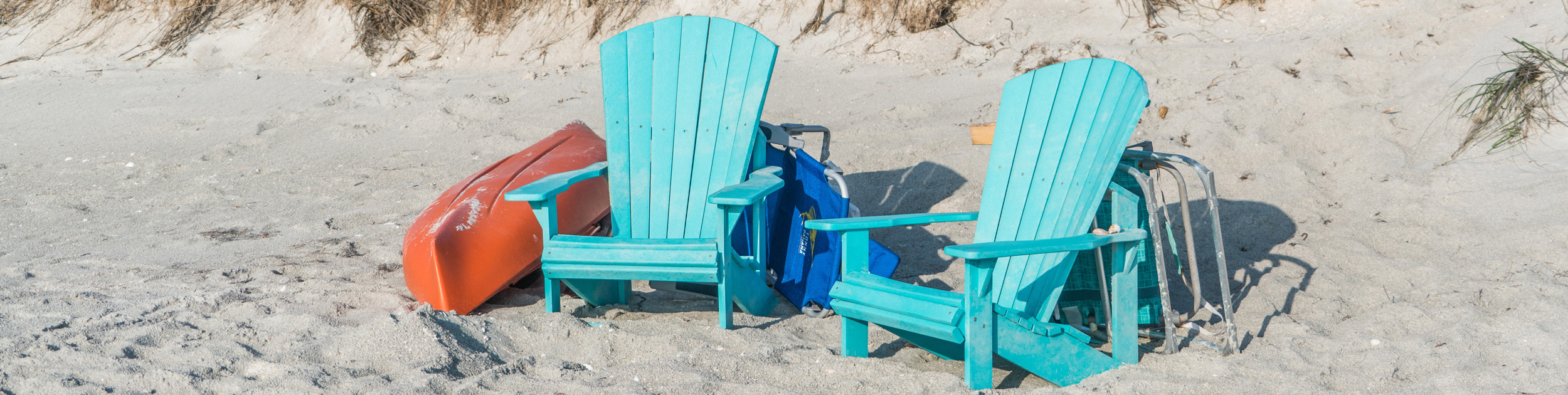 bright blue adirondack chairs on beach