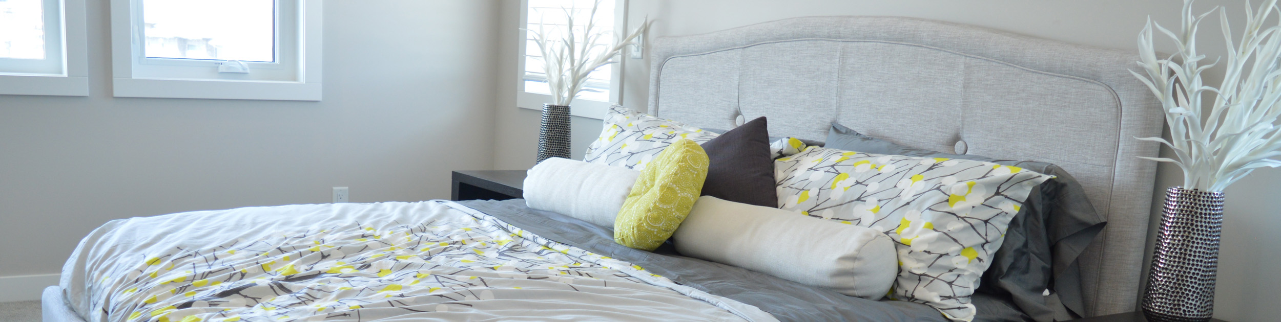 bedroom with gray white and yellow beddeing