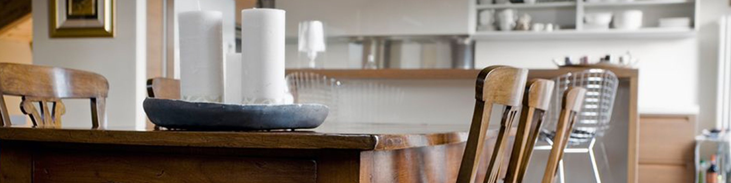 image of wooden kitchen island with white candles on top and wooden stools