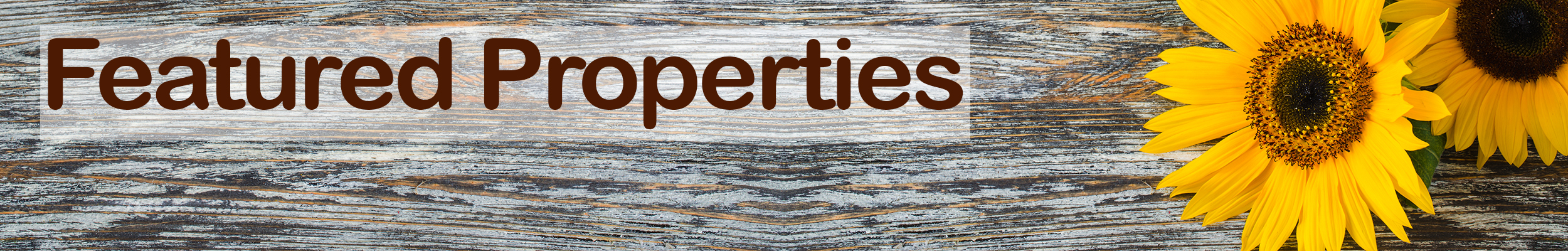 The words Featured Properties in brown on a wooden background with sunflowers